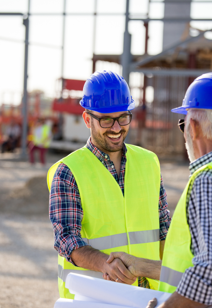 Two,Engineers,Shaking,Hand,On,Building,Site,With,Metal,Construction